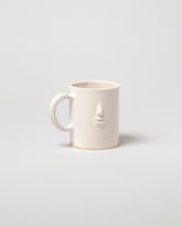 Rami Kim Face Mug on light color background.