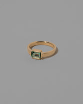 View from the side of the Emerald Fold Ring on light color background.