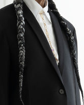 Styled image on model featuring the Sapphire Gusher Openable Pendant connected to a closed-loop oval link of the Link Necklace worn as a lariat, and a Bruised Banana Peel Charm and Red Apple Core Charm suspended from its Gold Coiled Swivel Charm Holder clasp.