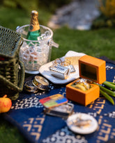 Styled image of the Saltine Butter Charms, with Salted Butter Charm, Caviar Charm, Sardine Can Charm and Luna Ring Charm.