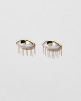 View from the side of the Pearl Eye Earrings on light color background.