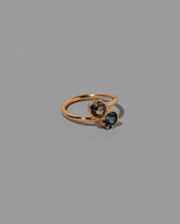 View from the side of the Sapphire Sun & Moon Union Ring on light color background.