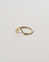 View from the side of the Gold Solid Round Wire Triangle Band on light color background.