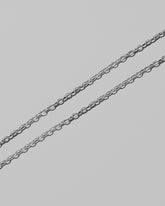 Closeup details of the CRZM 2mm Sterling Silver Short Loop Chain Necklace on light color background.
