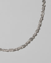 Closeup details of the CRZM Sterling Silver Torsional Chain Necklace on light color background.