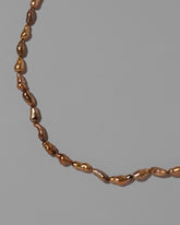 Closeup details of the Scylla Necklace on light color background.