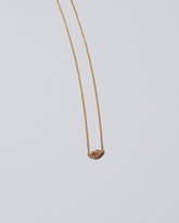 Closeup detail of the Light Pink Big Kiss Necklace on light color background.