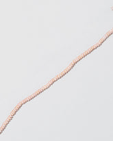 Closeup details of the Pink Peony Pebble Seed Pearl Choker Necklace on light color background.