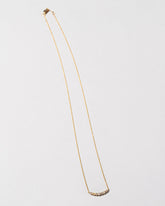White Diamond Crescent Necklace on light color background.