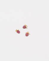 Diamond & Ruby Pavé Strawberry Charm and Ruby Pavé Strawberry Charms on light color background.