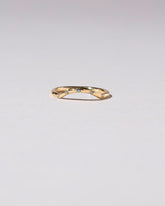 Gold Five Stone Blue Sapphire Mini Curve Band on light color background.
