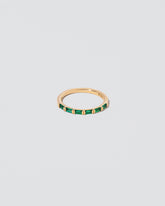 Gold Emerald Bar Baguette Band on light color background.