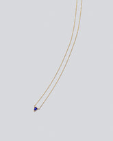 Gold Lapis Triangle Necklace on light color background.