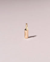 Bottle of Beer Charm on light color background.