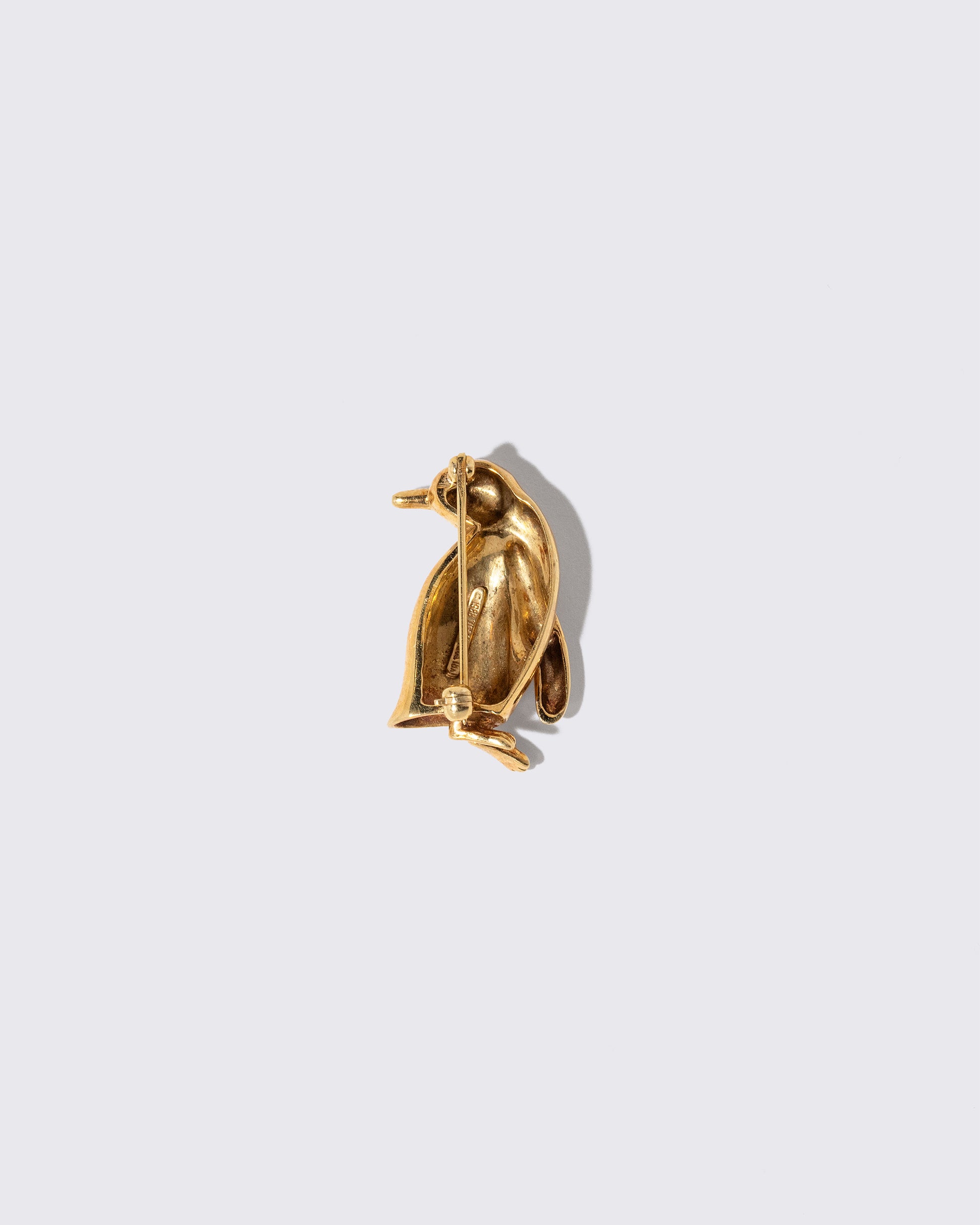 View from the back of the Vintage Tiffany & Co. Penguin Brooch on light color background.