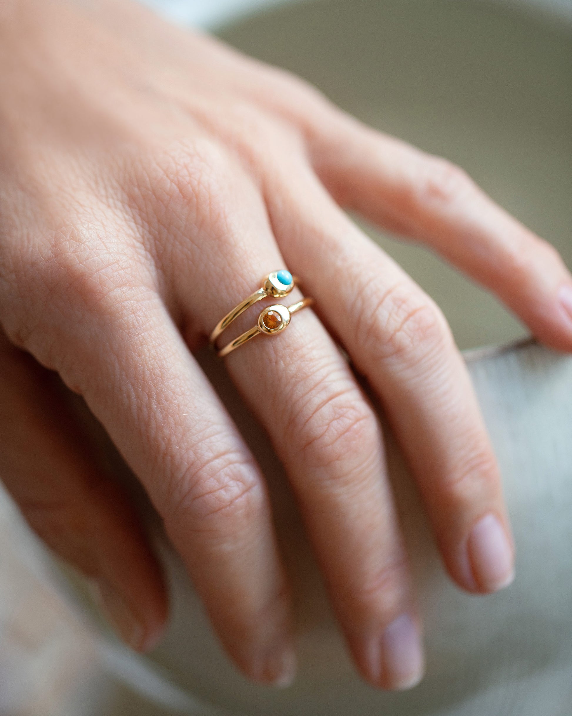 View from the side of the Citrine Birthstone Level Ring on light color background.
