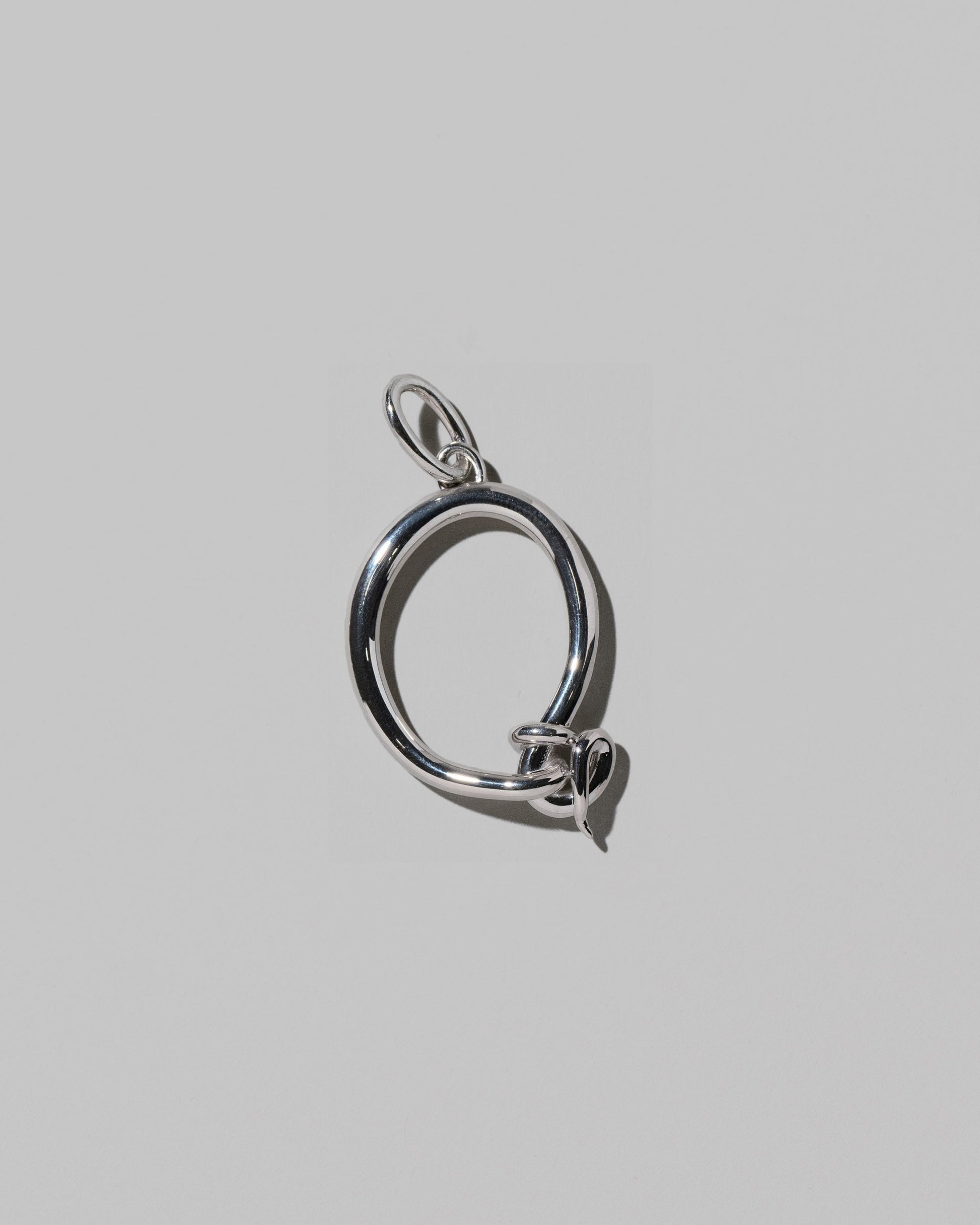 CRZM Sterling Silver Letter Q Bag Charm on light color background.