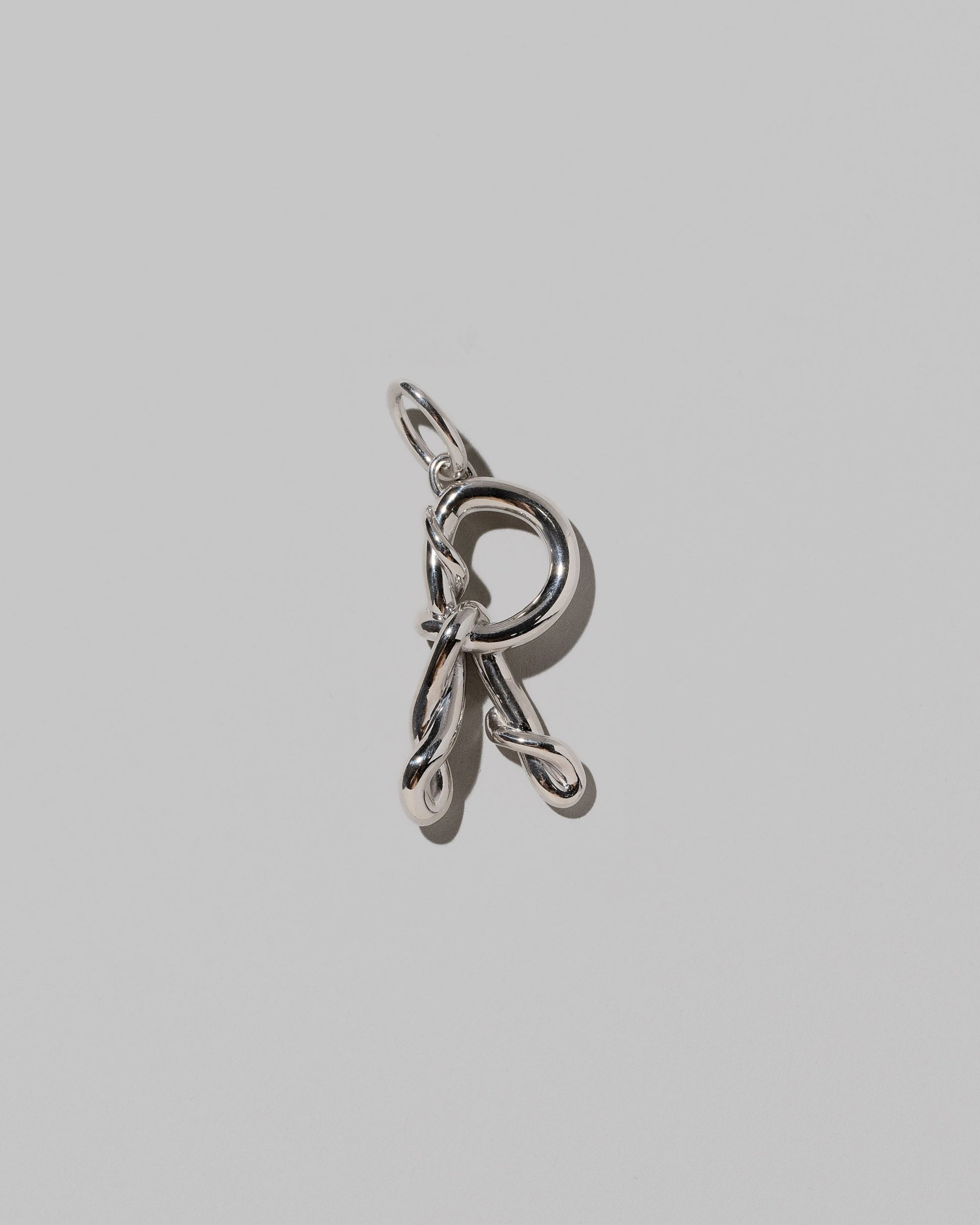CRZM Sterling Silver Letter R Bag Charm on light color background.