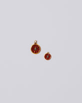 Large Tangerine Slice Charm and Small Tangerine Slice Charm on light color background.