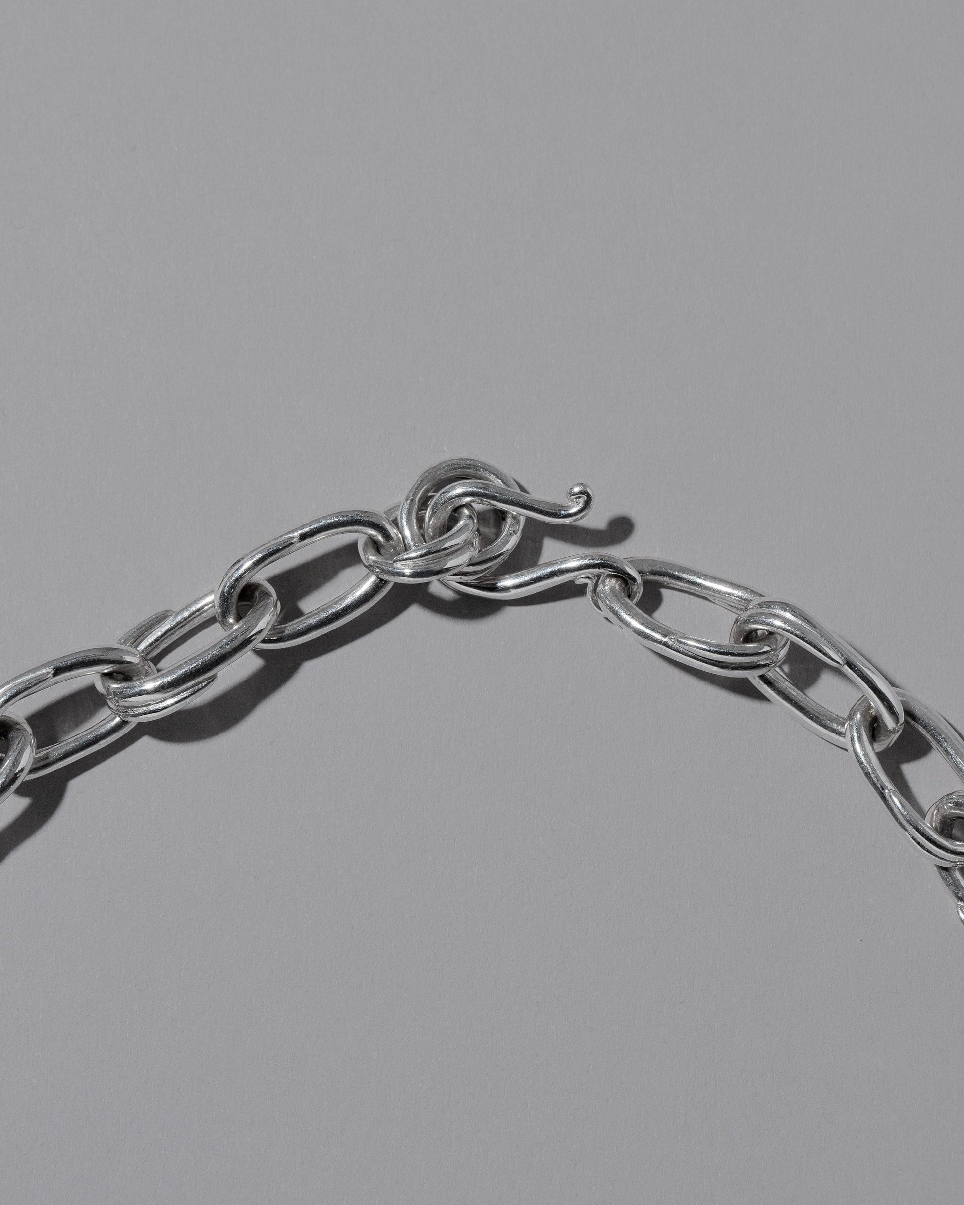 Closeup details of the CRZM Sterling Silver Canyon Necklace on light color background.