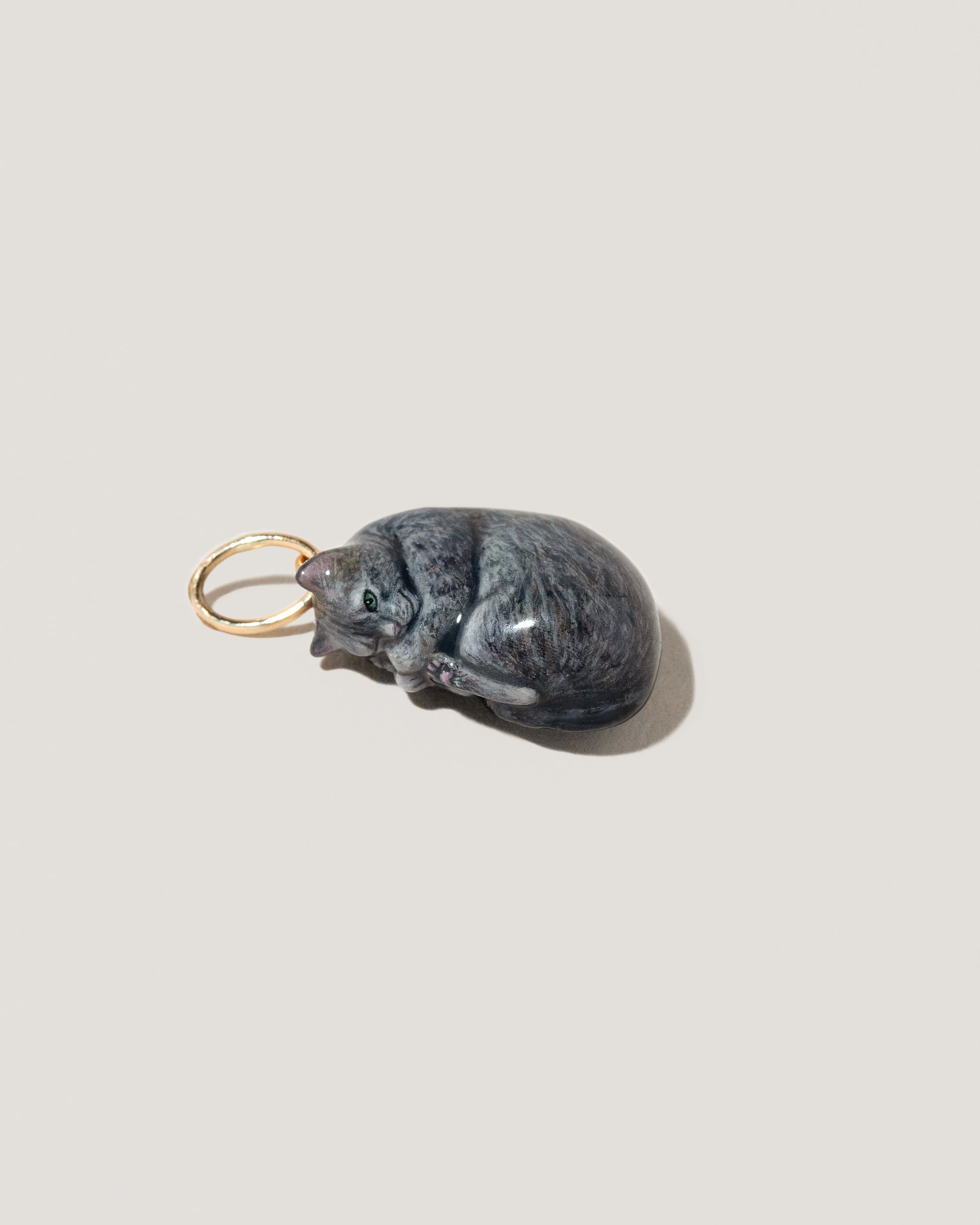 Example of a Customized Curled-Up Cat Charm on light color background.