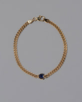 Gold Blue Sapphire Fold Bracelet on grey color background.