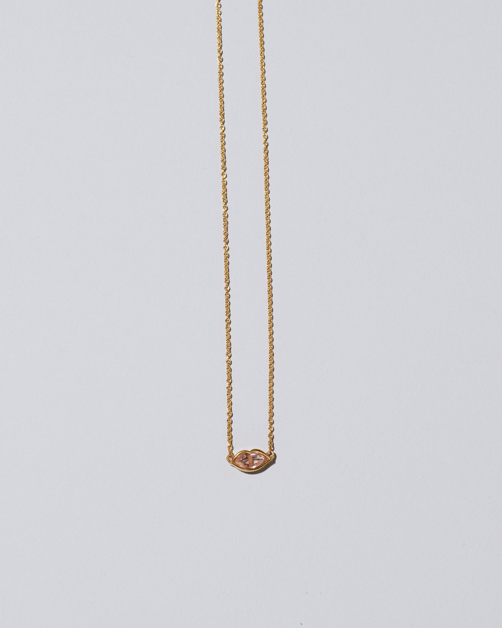 Light Pink Big Kiss Necklace on light color background.