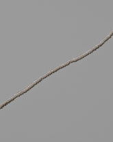 Closeup details of the White Pebble Seed Pearl Choker Necklace on light color background.