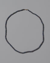 Peacock Round Seed Pearl Necklace on light color background.