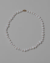 Cardinal Red Thread Bubble Pearl Necklace on light color background.