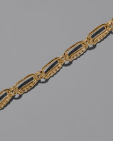 Closeup details of the CRZM Gold Ophiolite Bracelet on light color background.
