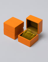 Earrings & Charms Orange Lacquer Box on light color background.