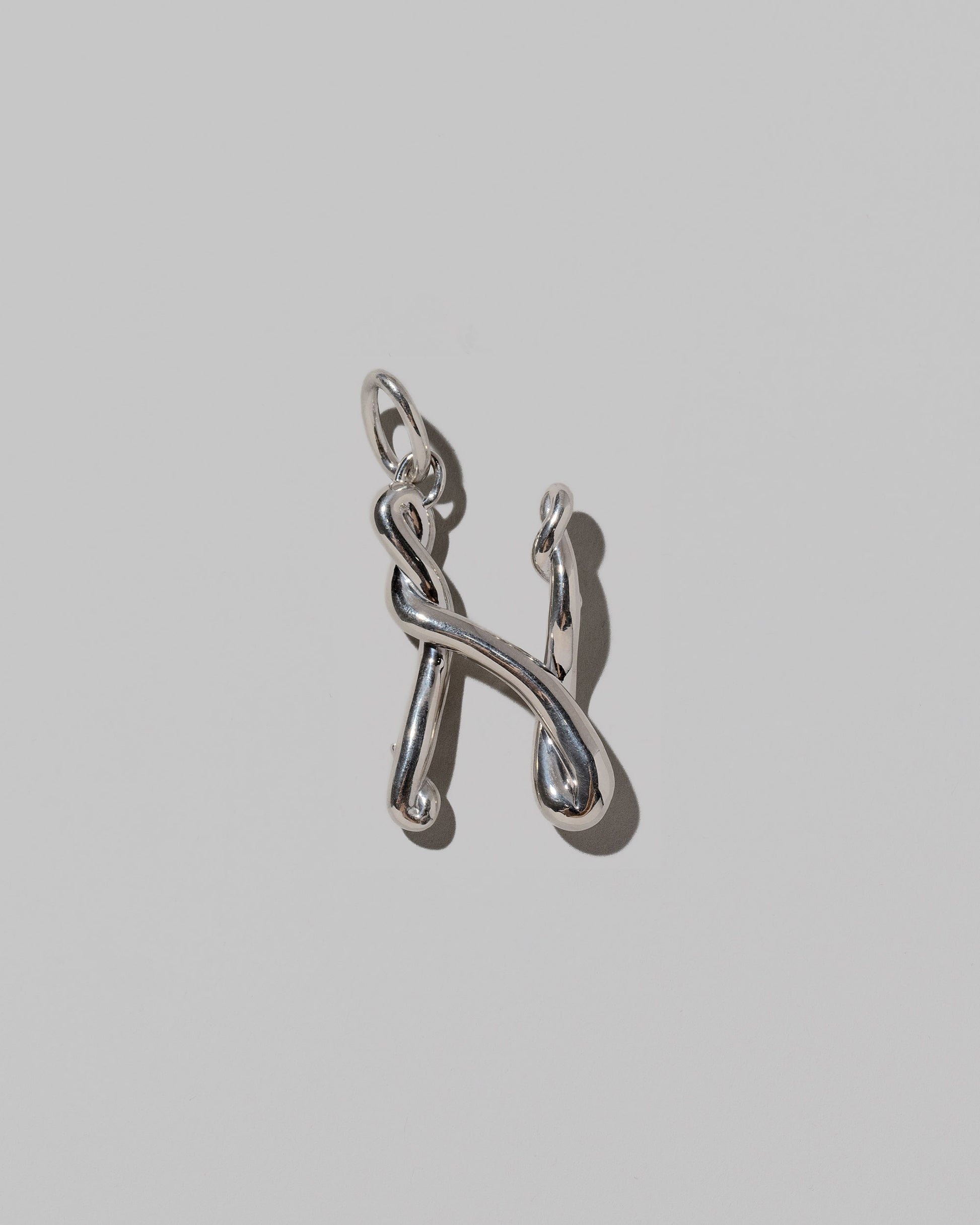 CRZM Large Letter N Charm set in sterling silver on light color background.
