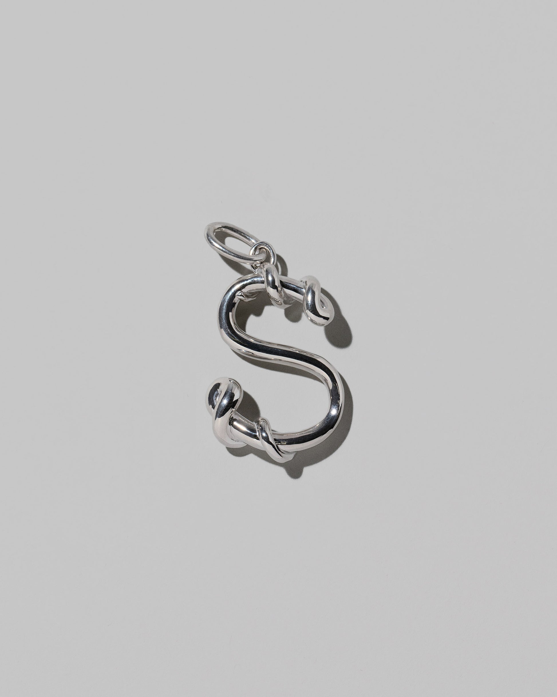 CRZM Large Letter S Charm set in sterling silver on light color background.