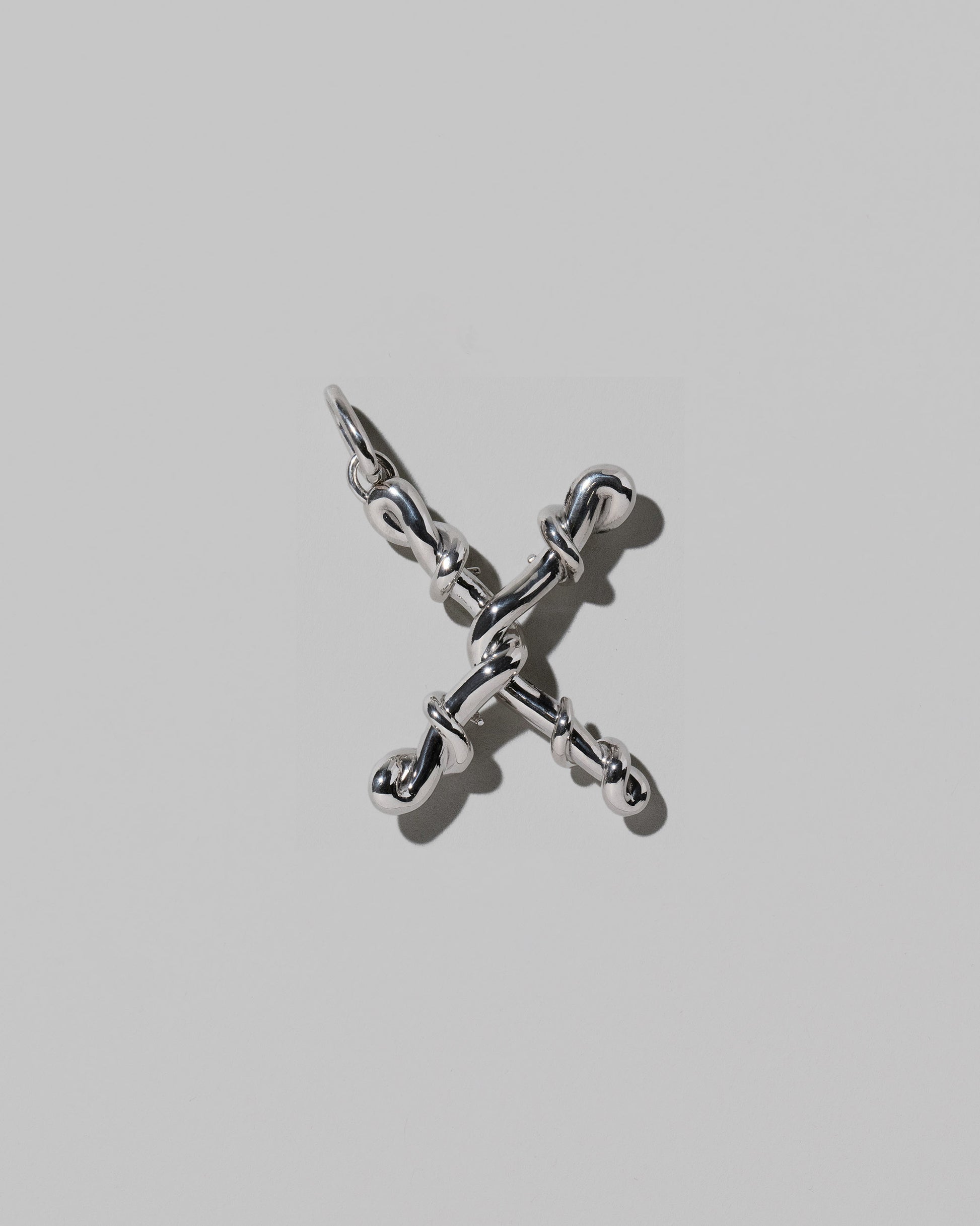 CRZM Large Letter X Charm set in sterling silver on light color background.