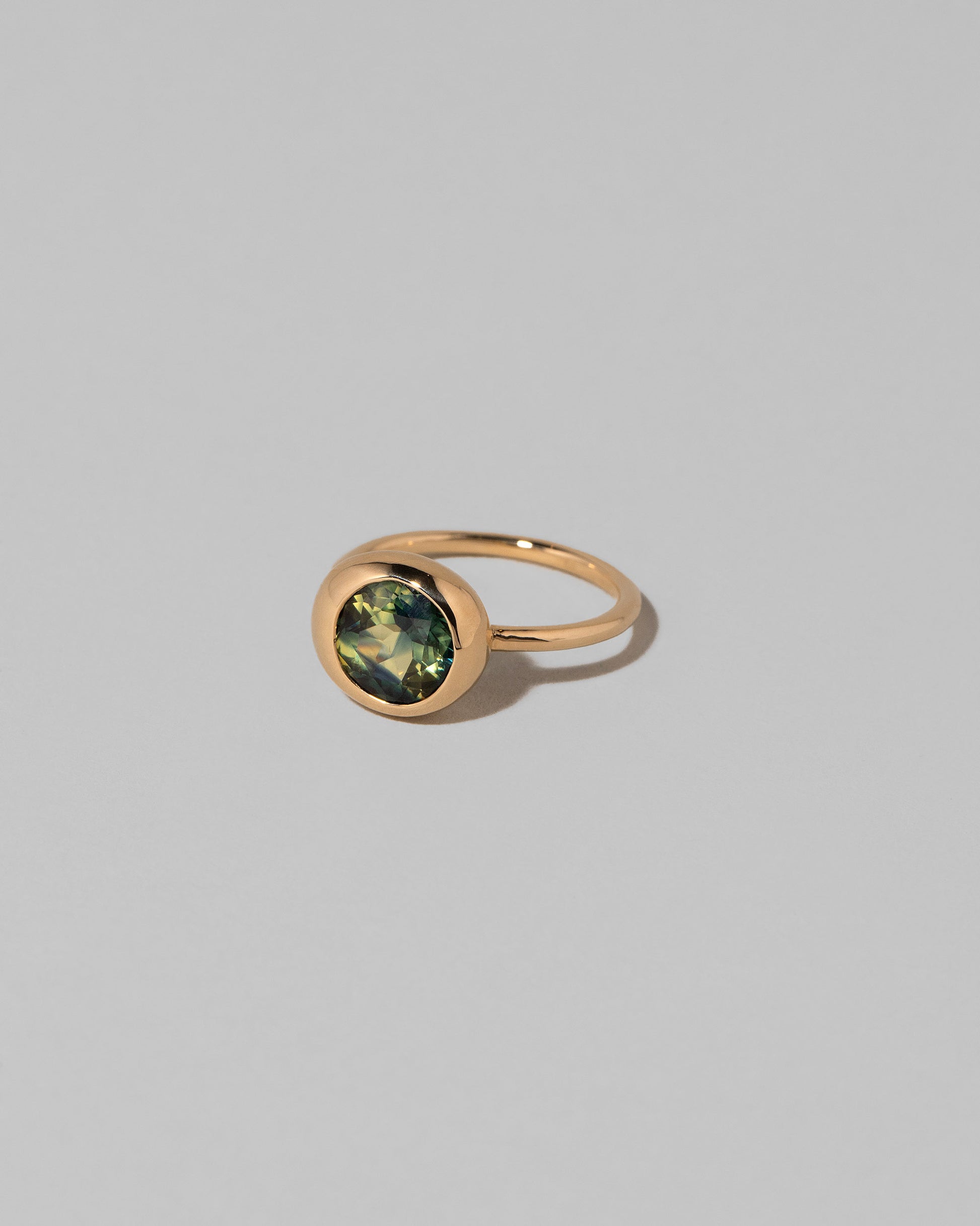 View from the side of the Bicolor Sapphire Grand Level Ring on light color background.