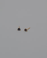 Purple Sapphire Martini Stud Earrings on light color background.