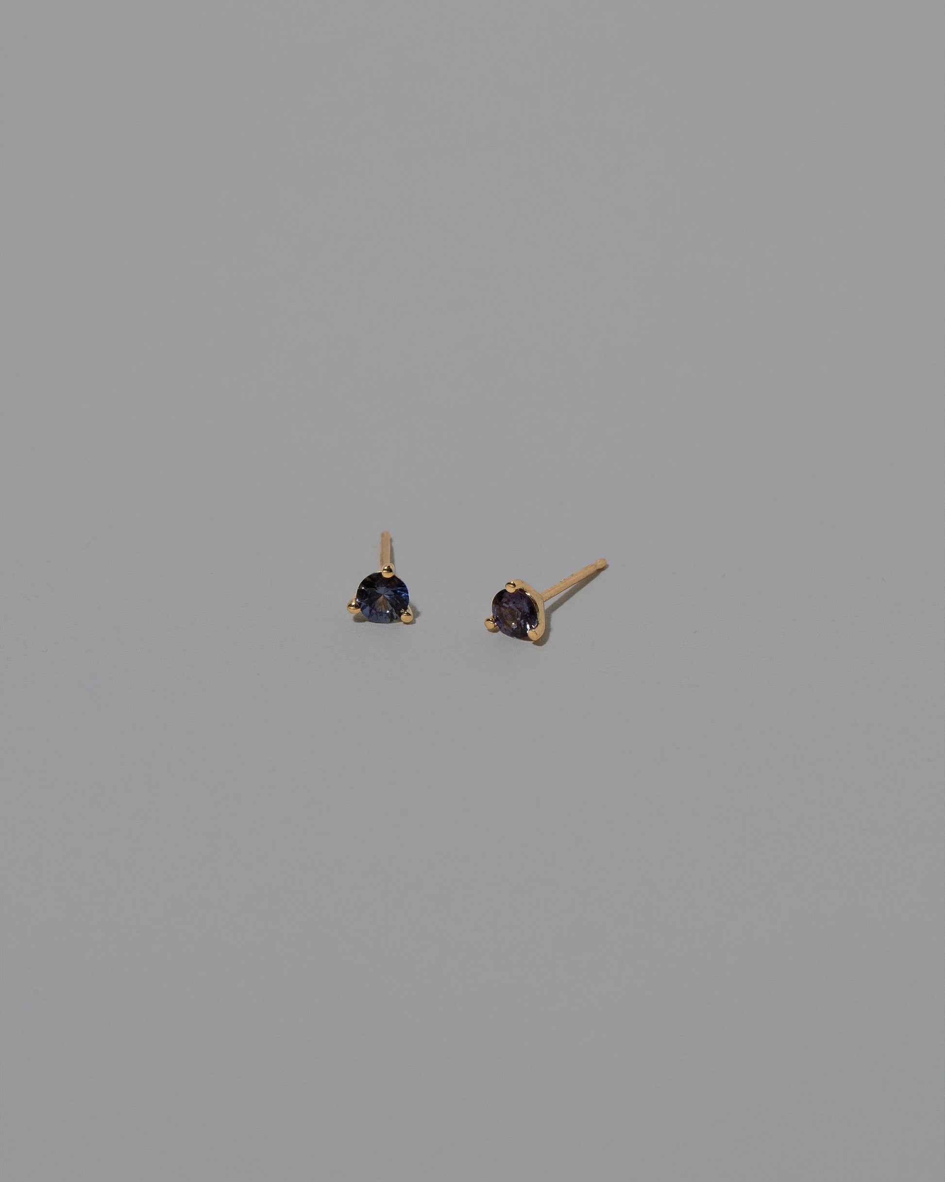 Purple Sapphire Martini Stud Earrings on light color background.
