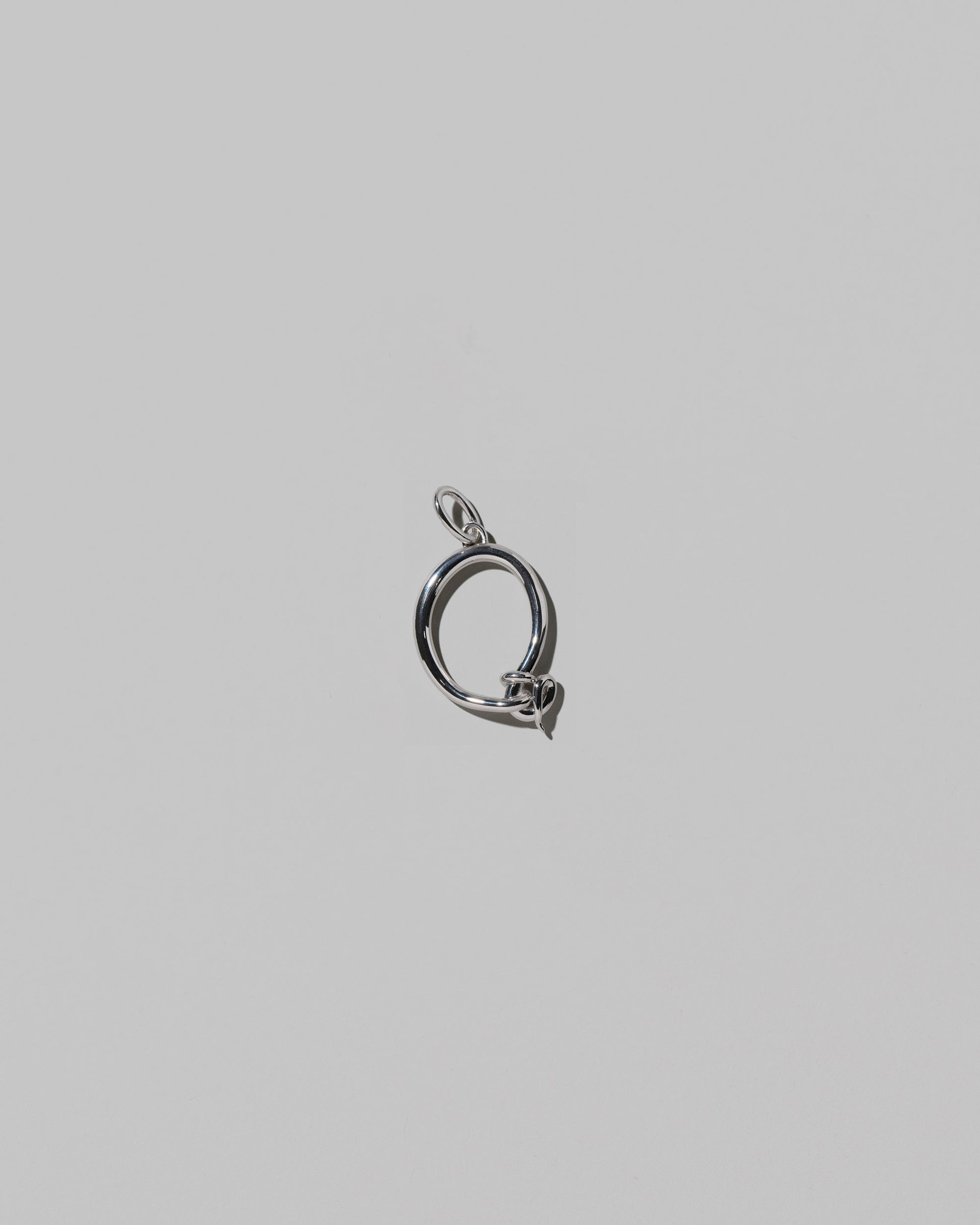 CRZM Medium Letter Q Charm set in sterling silver on light color background.