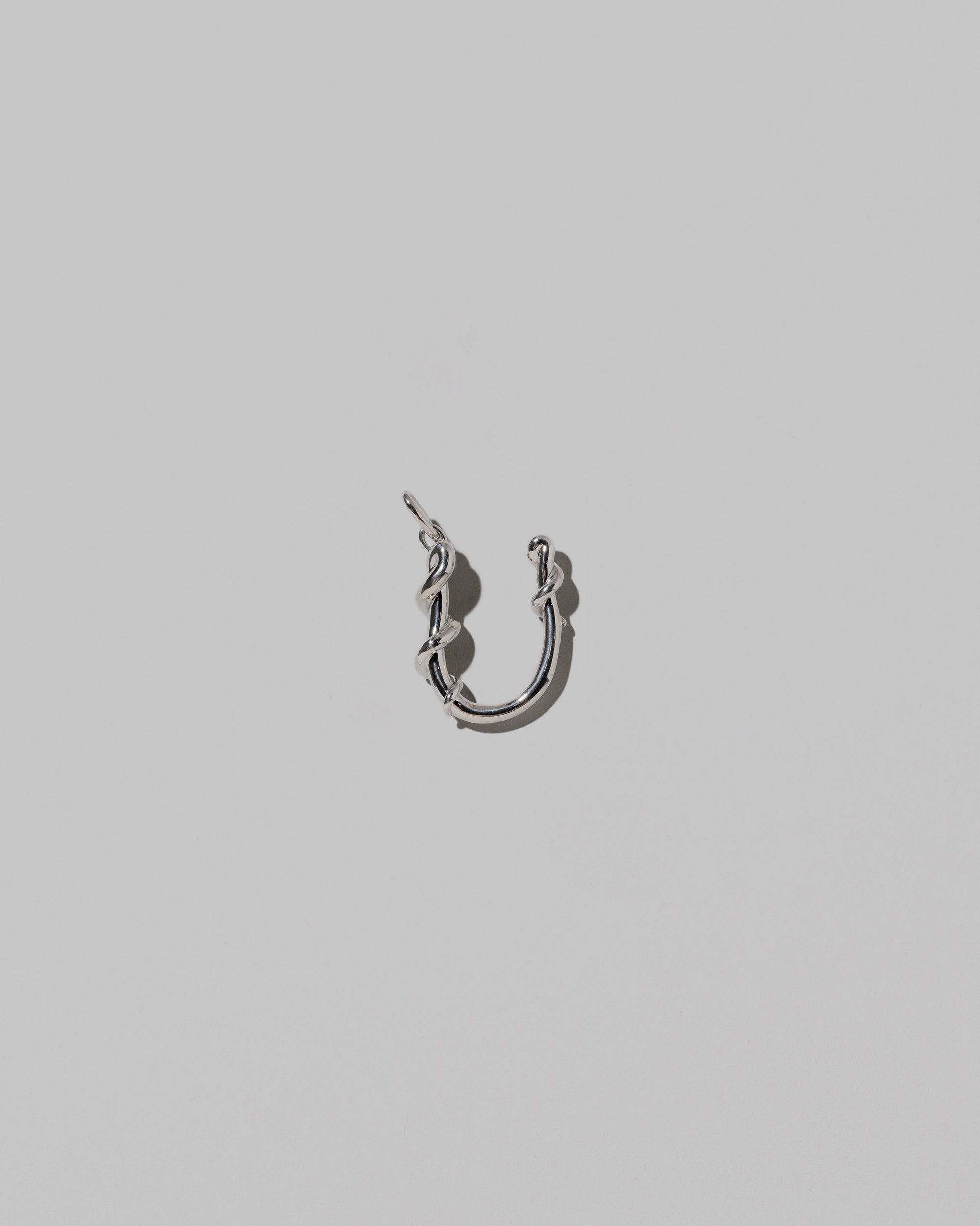 CRZM Medium Letter U Charm set in sterling silver on light color background.