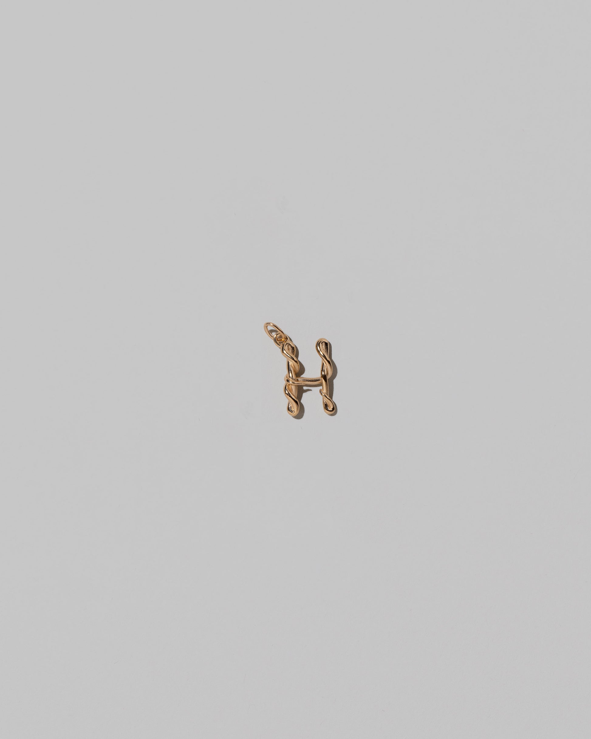 CRZM Mini Letter H set in solid gold on light color background.