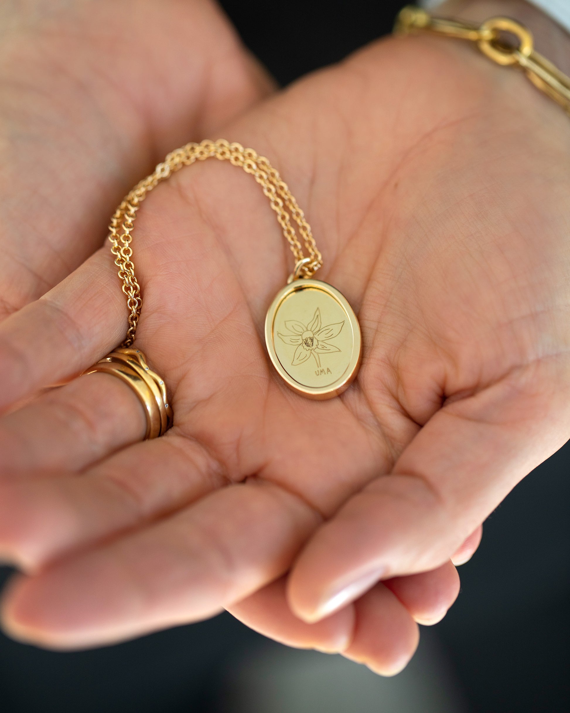 Finished Large Oval Memento Necklace engraved with children's drawing in hand.