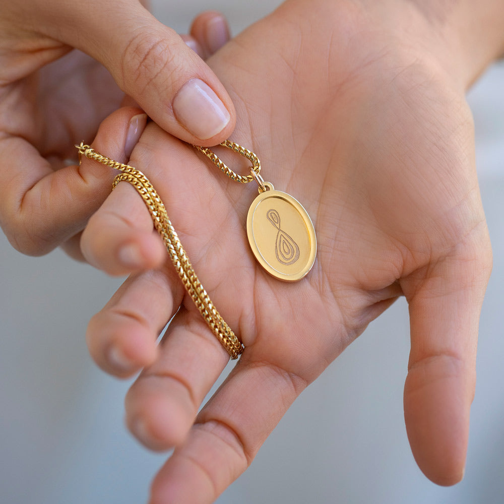 product_details::Gold Small Oval Pendant Without Chain Memento Pendant and Gold Large Oval Pendant Without Chain Memento Pendant on light color background.