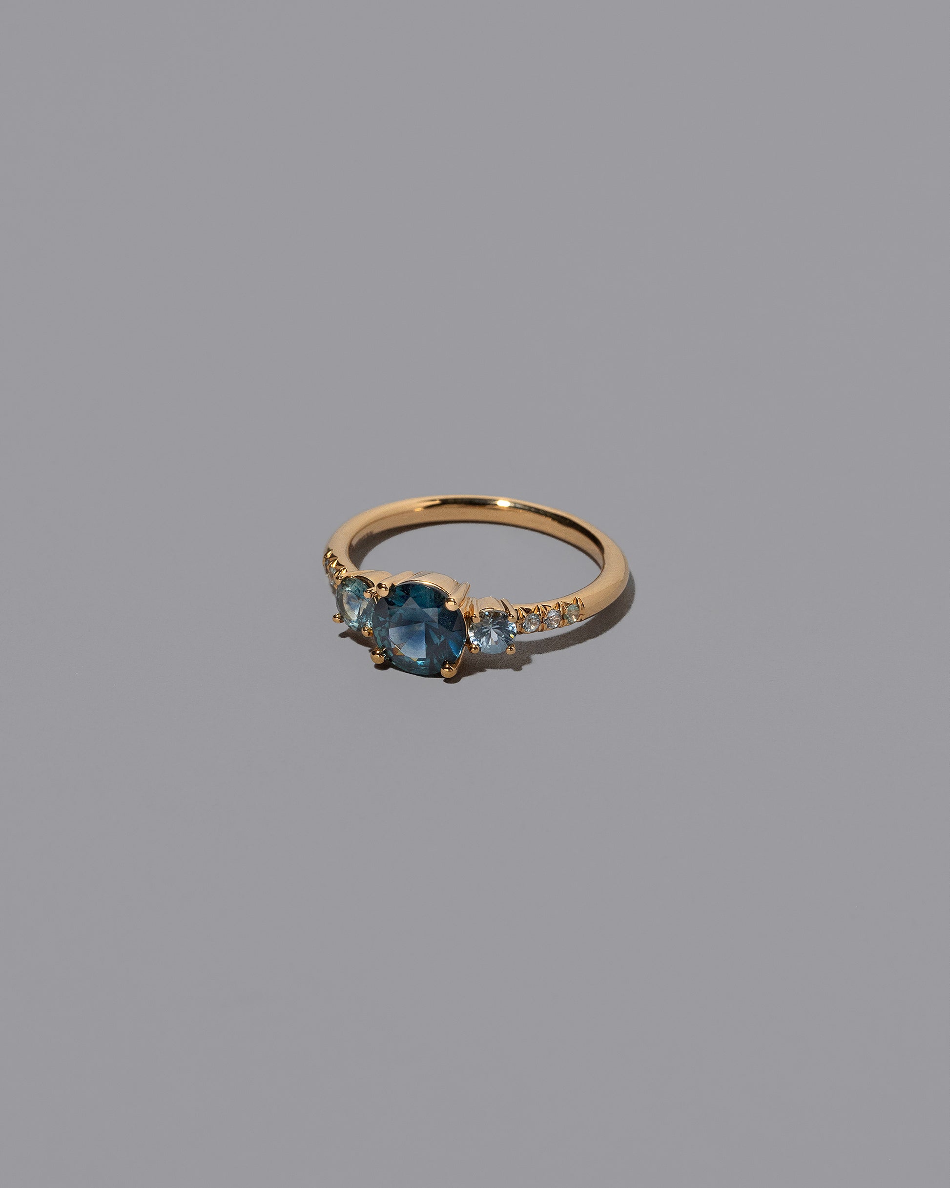 View from the side of the Sapphire Orion Ring on grey color background.