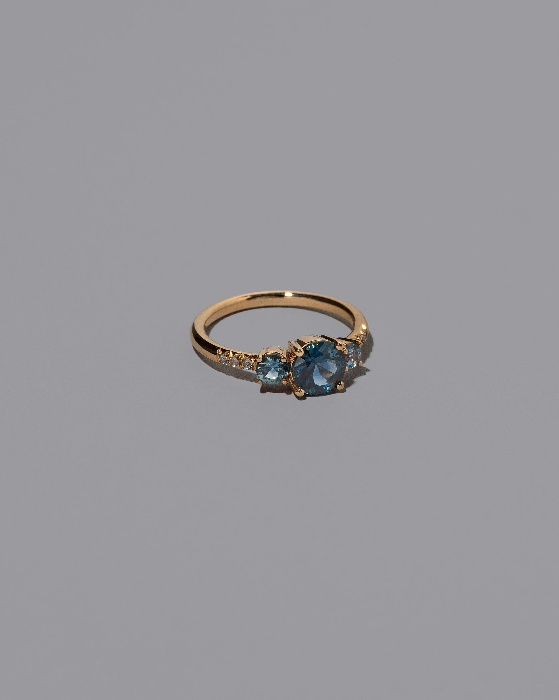 View from the side of the Sapphire Orion Ring on grey color background.