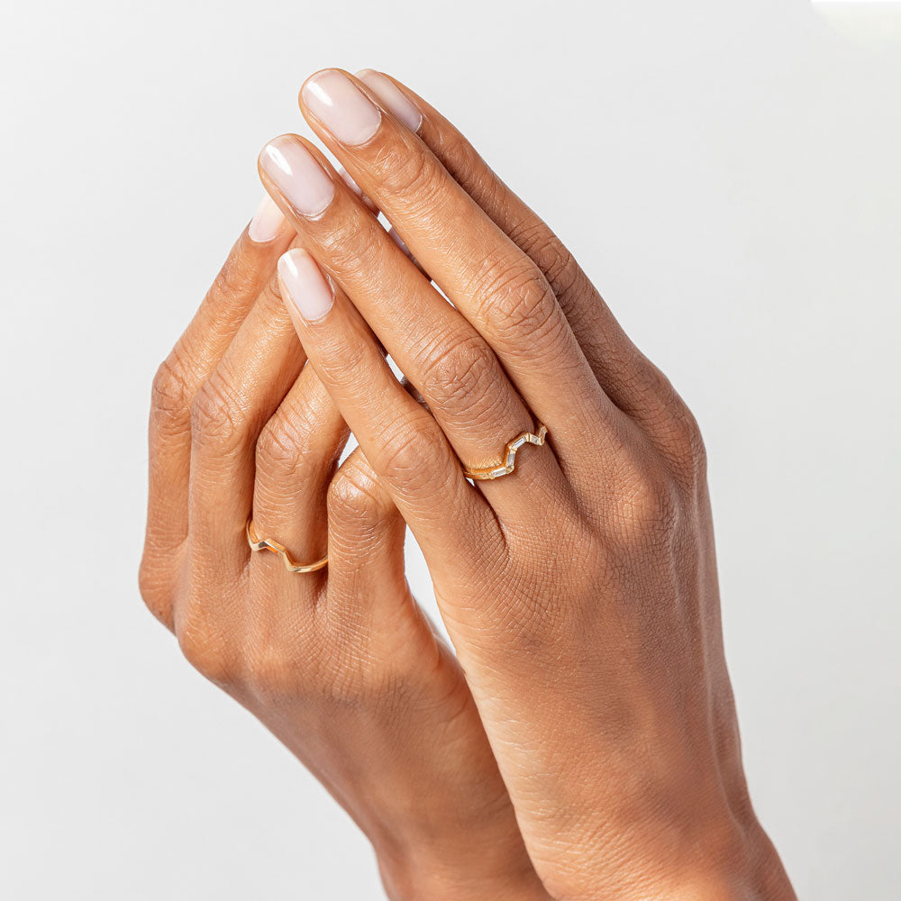 product_details::Gold Solid and Gold White Diamond Baguette Bridge Bands on model.