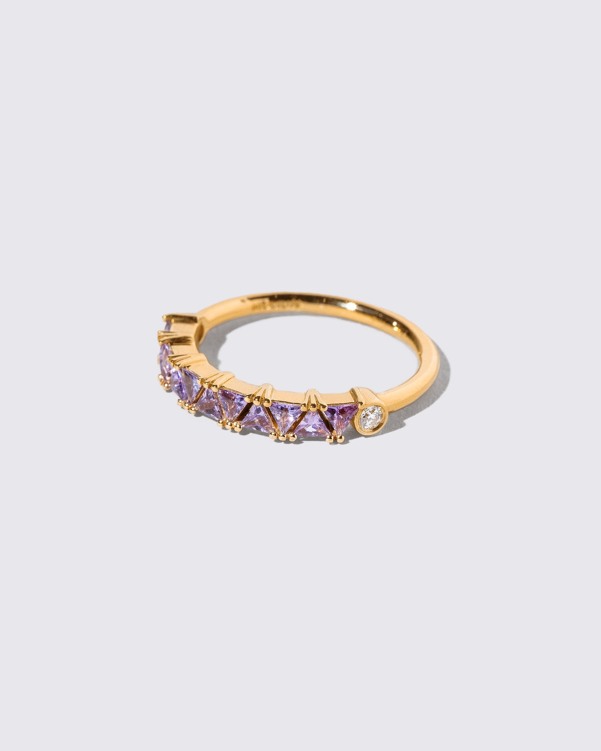 View from the side of the Lavender Sapphire Eleven Trillion Ring on light color background.