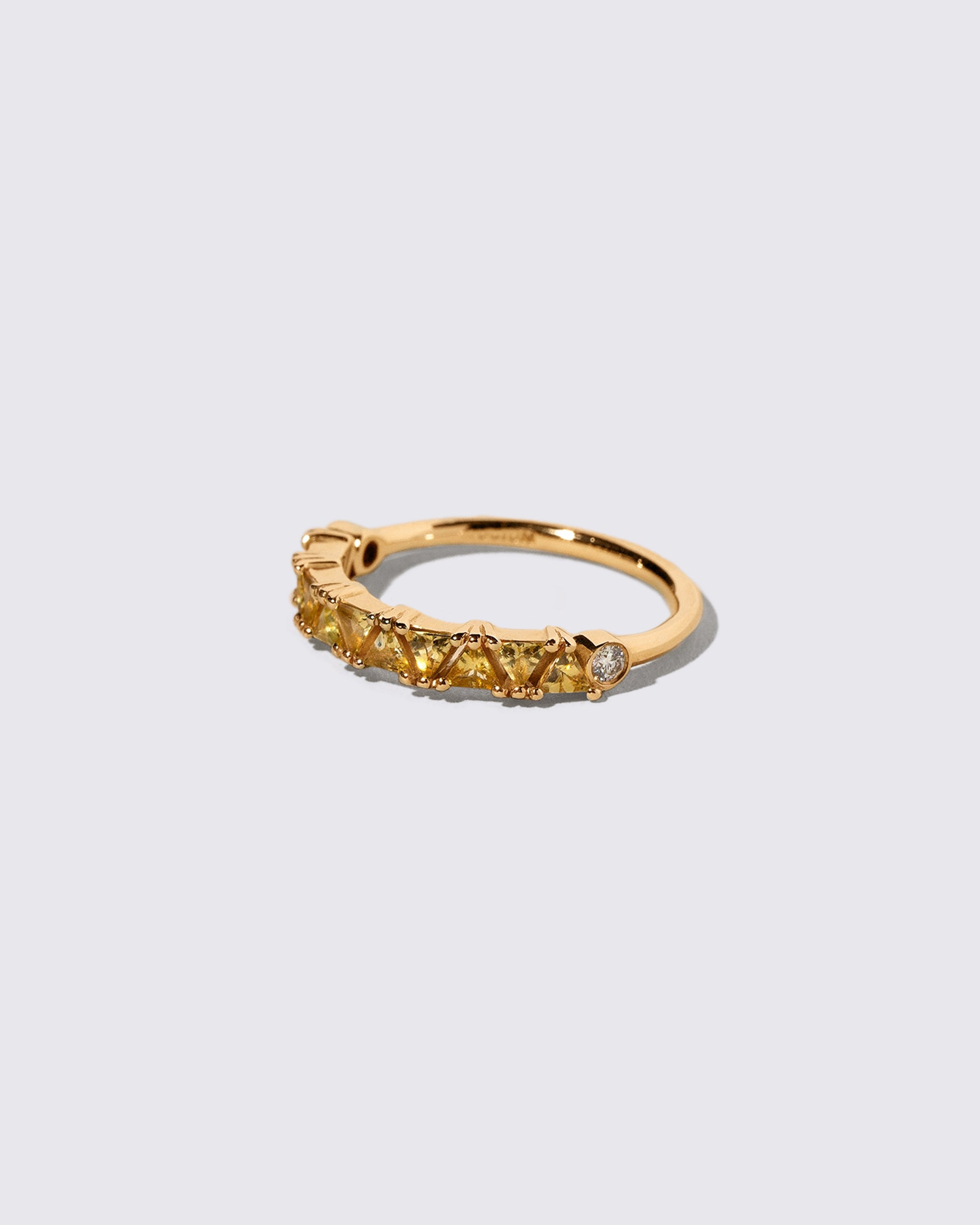 View from the side of the Yellow Sapphire Eleven Trillion Ring on light color background.