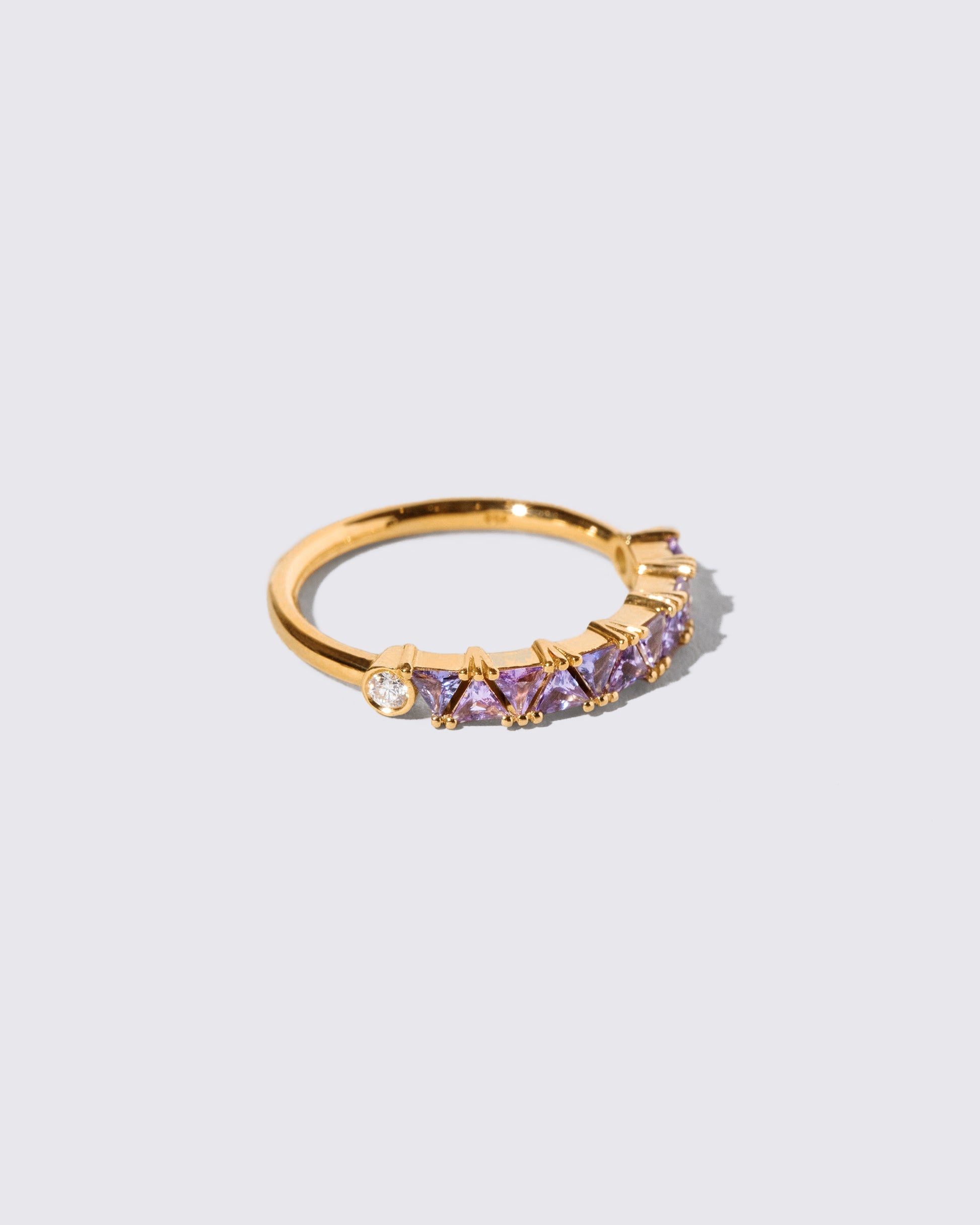 View from the side of the Lavender Sapphire Eleven Trillion Ring on light color background.