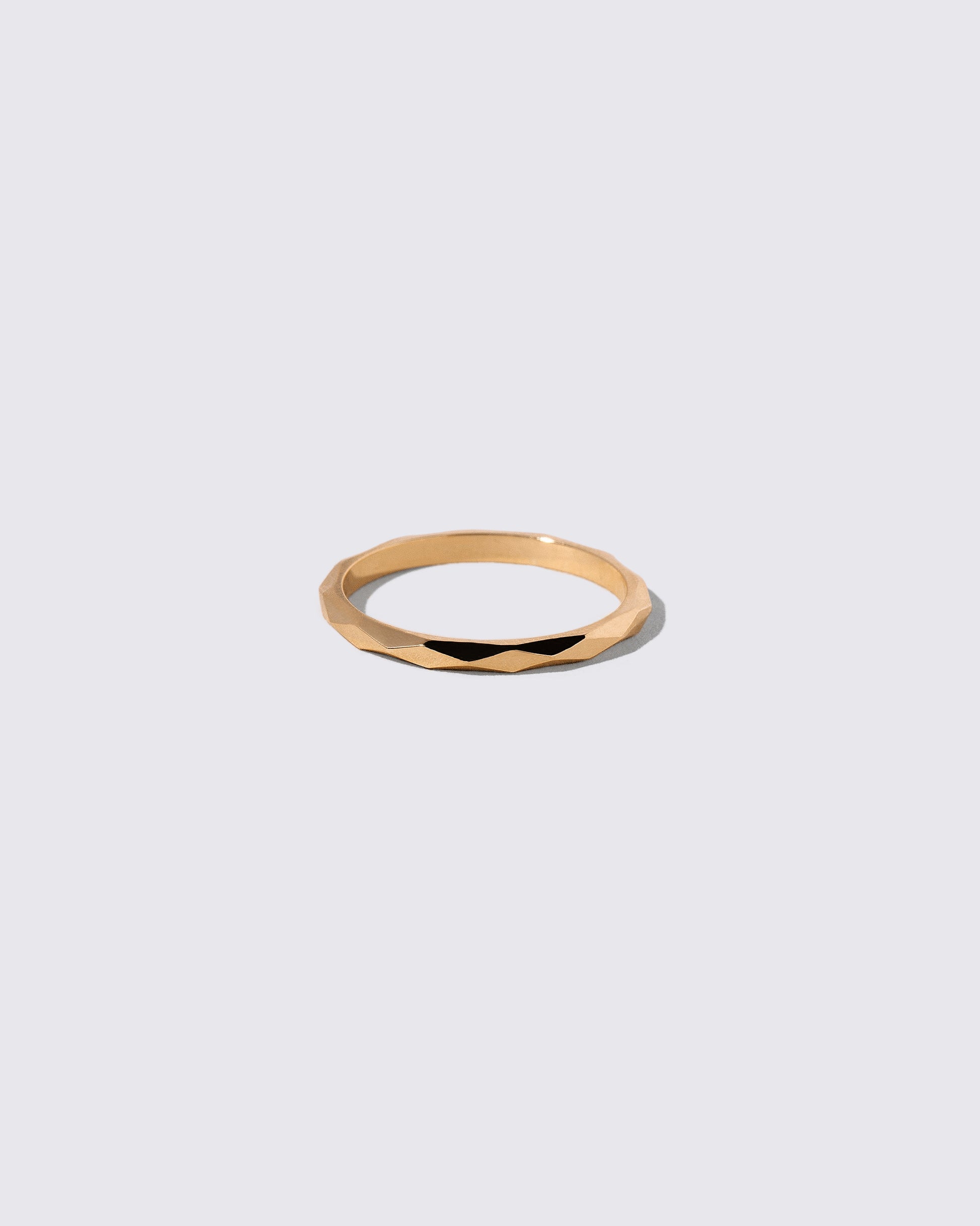 Gold 2mm Facet Band on light color background.